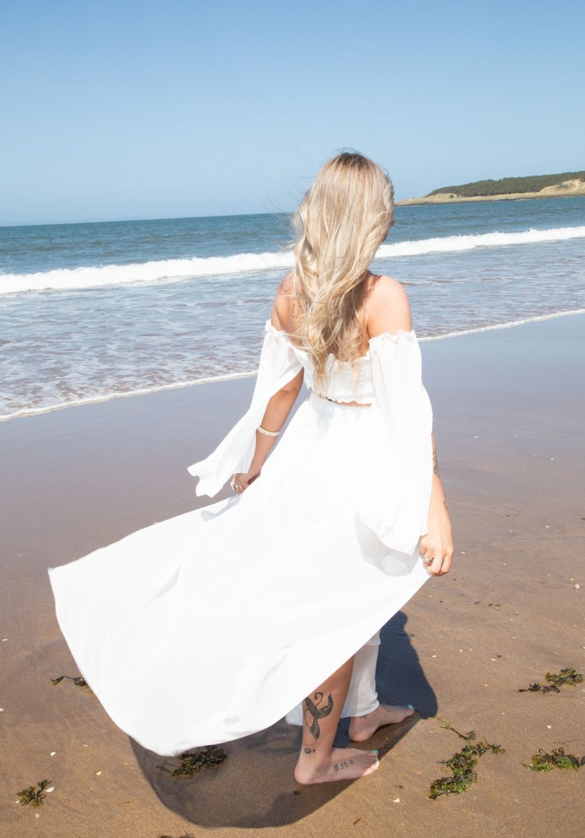 Brand photography on the beach in a flowing white dress