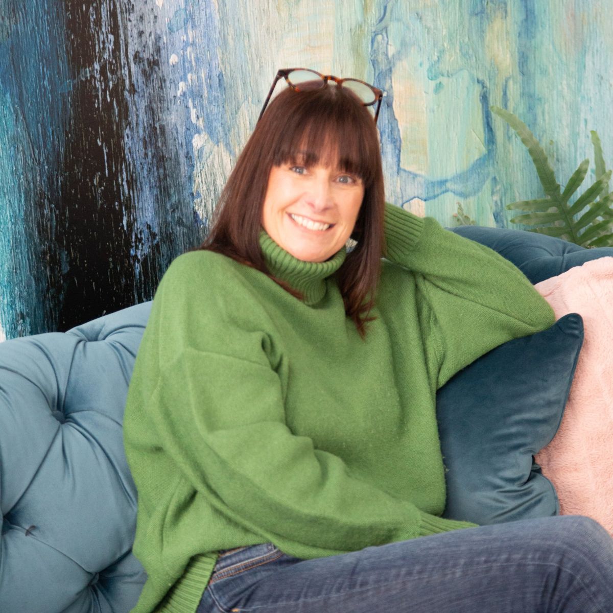 Business owner relaxing on a teal sofa