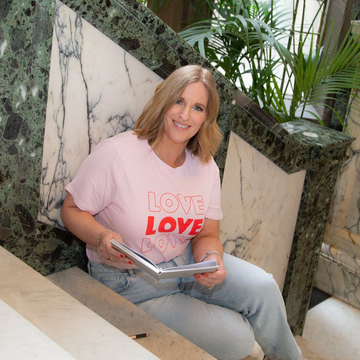 Business owner on marble stairs with a notebook