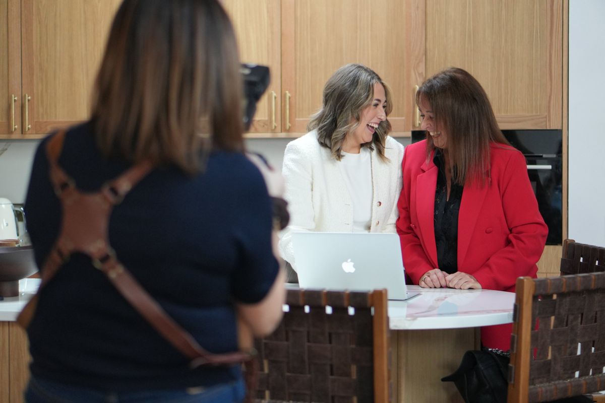 Jacqui photographing two women laughing at a laptop