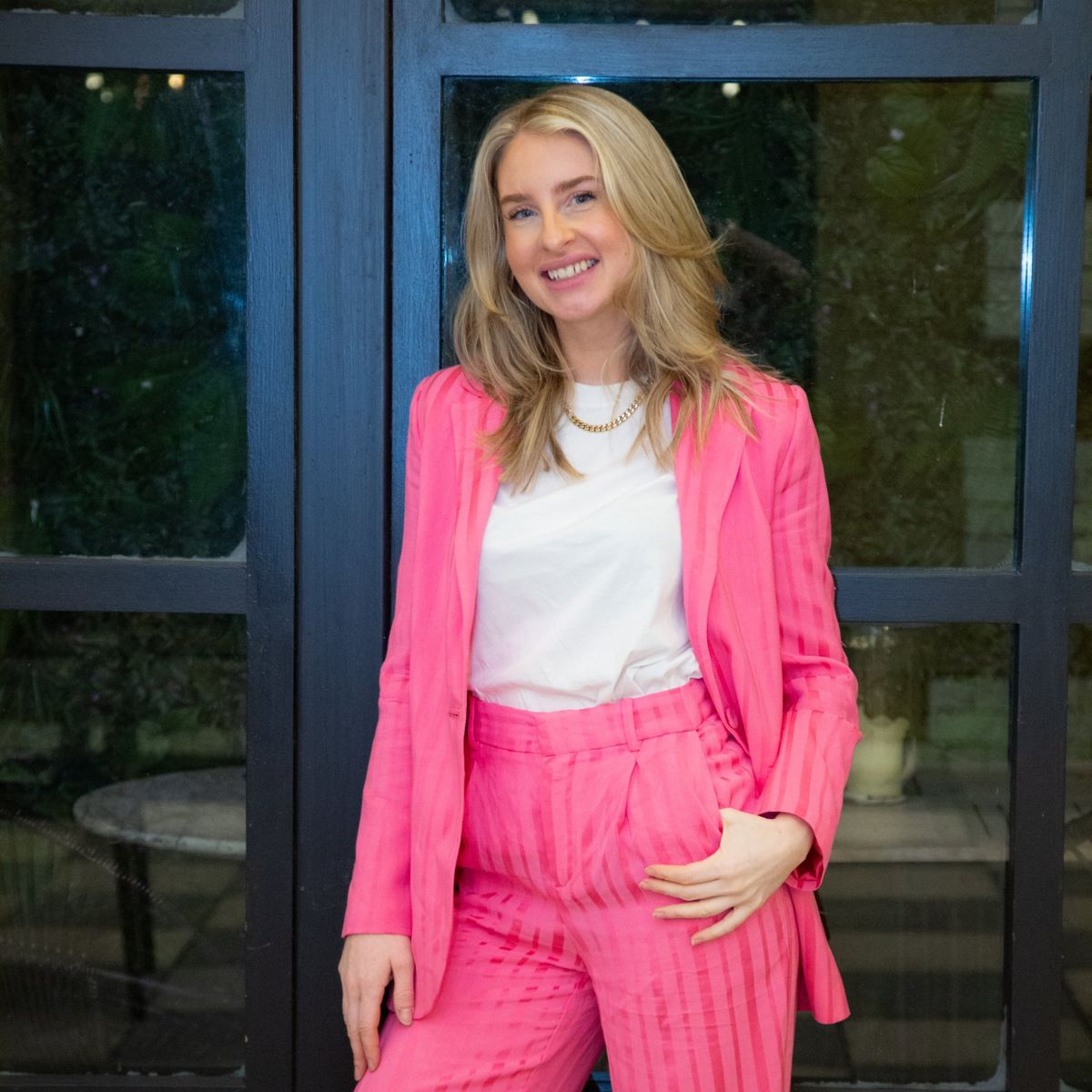 Business owner in a pink suit smiling at the camera