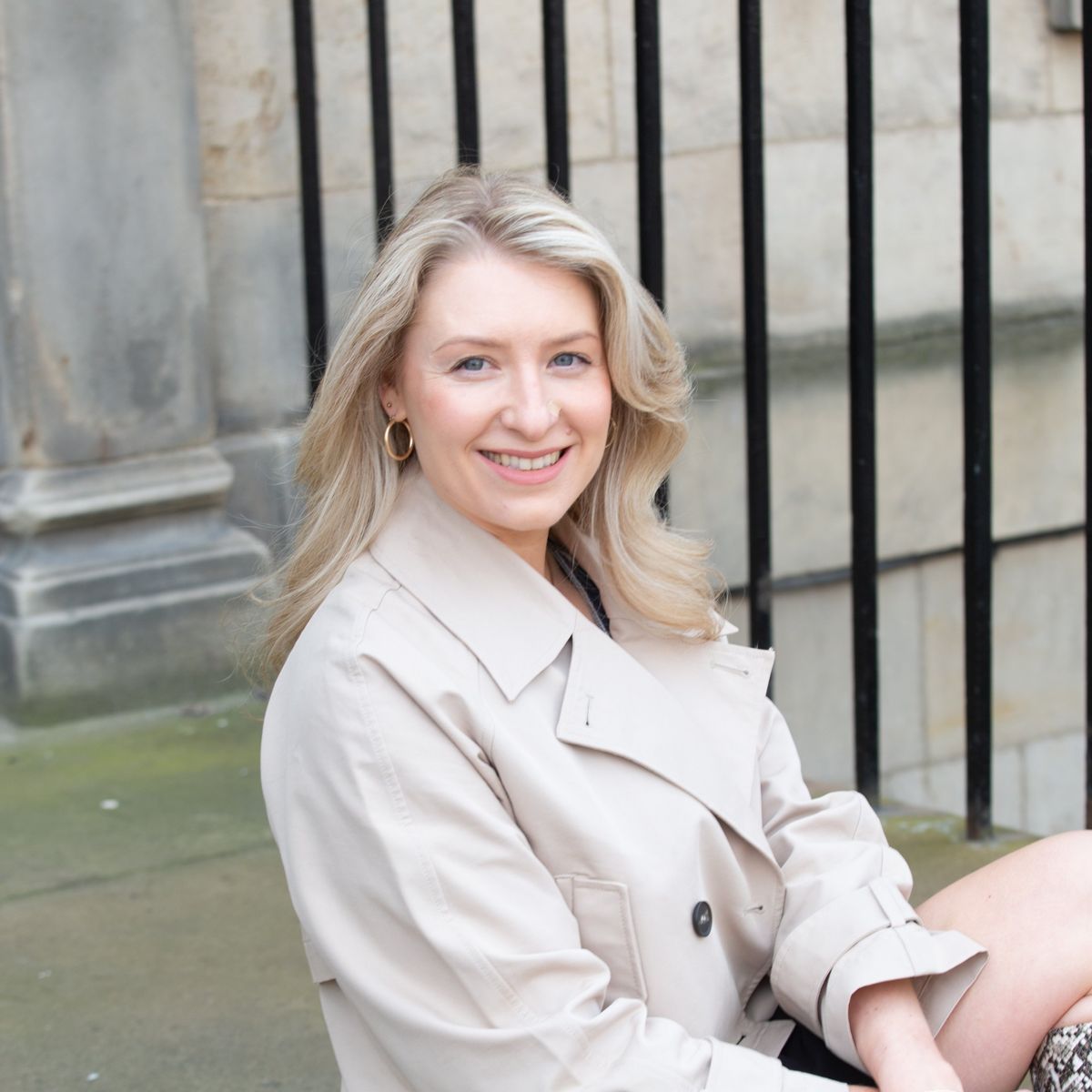 Business owner in a trench coat by Edinburgh railings