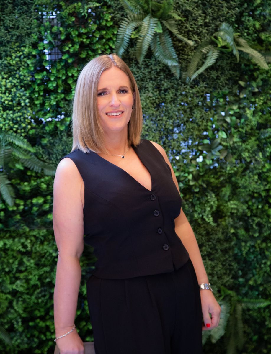 Business owner in front of a green wall